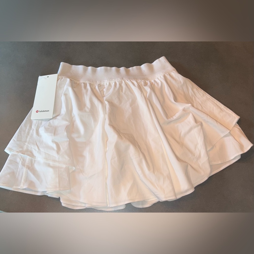 Never worn white Lululemon tennis skirt, built in shorts and side compartments.